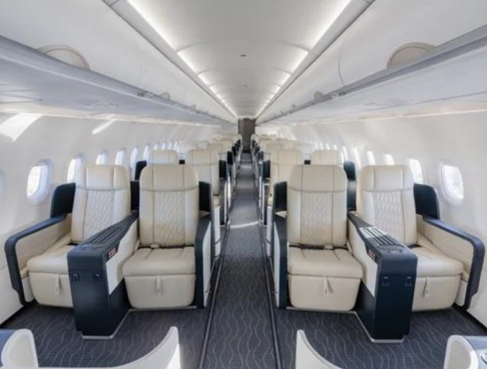 Inside the TCS World Travel jet: rows of cream leather flatbed seats in a wide private-jet cabin