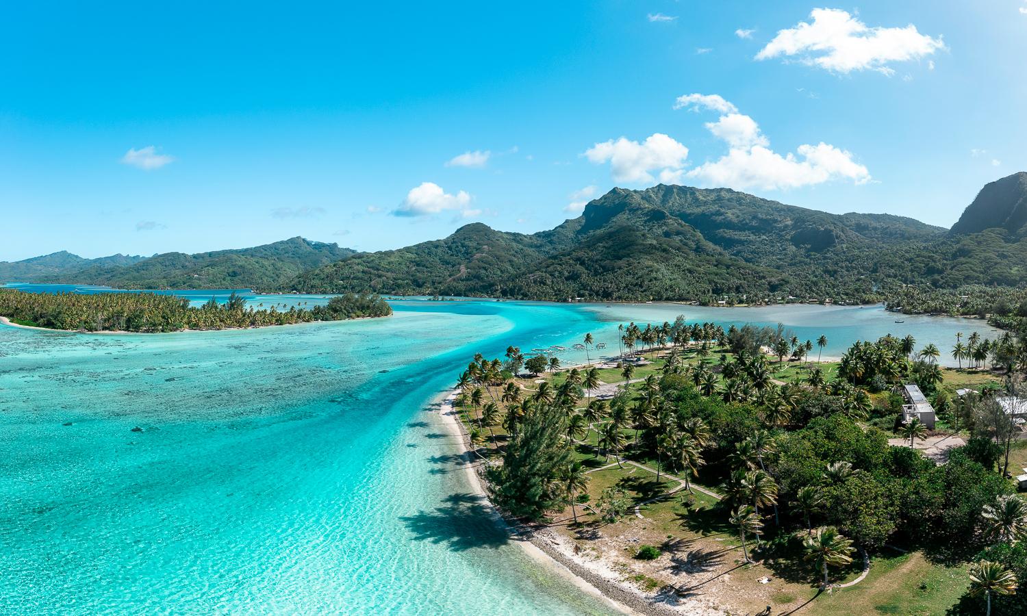 Turquoise lagoon, palm-lined shores and green mountains in Raiatea and Huahine, French Polynesia