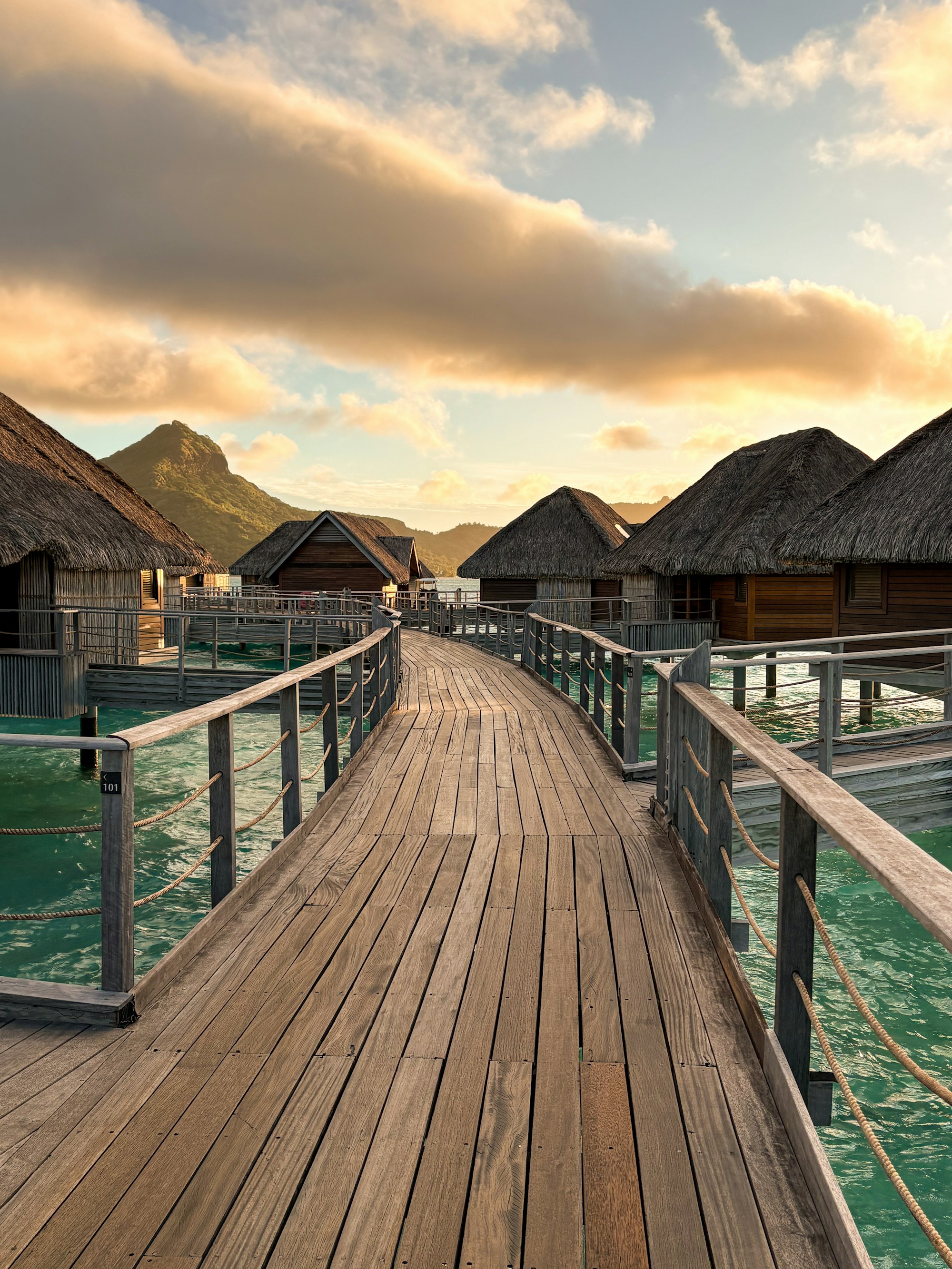 The boardwalk to overwater bungalows in Bora Bora with Mount Otemanu rising behind the lagoon