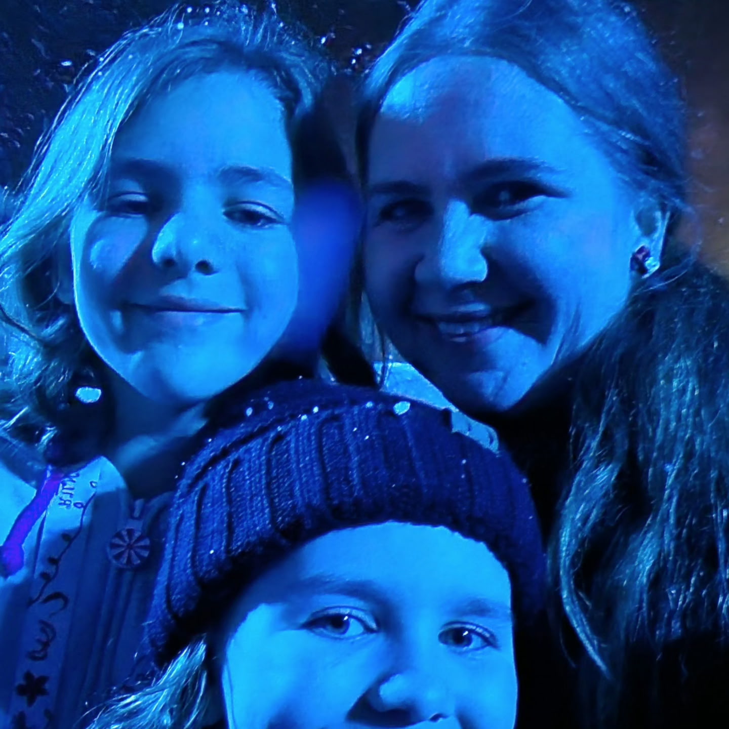 Kim Koldykowski with her daughters under blue lights at Walt Disney World