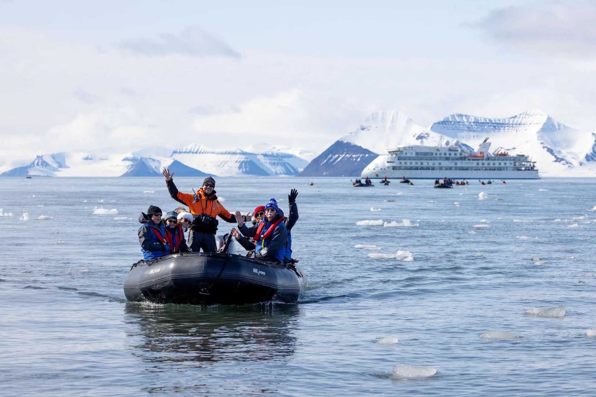 Expedition cruise guests in parkas on a Zodiac landing