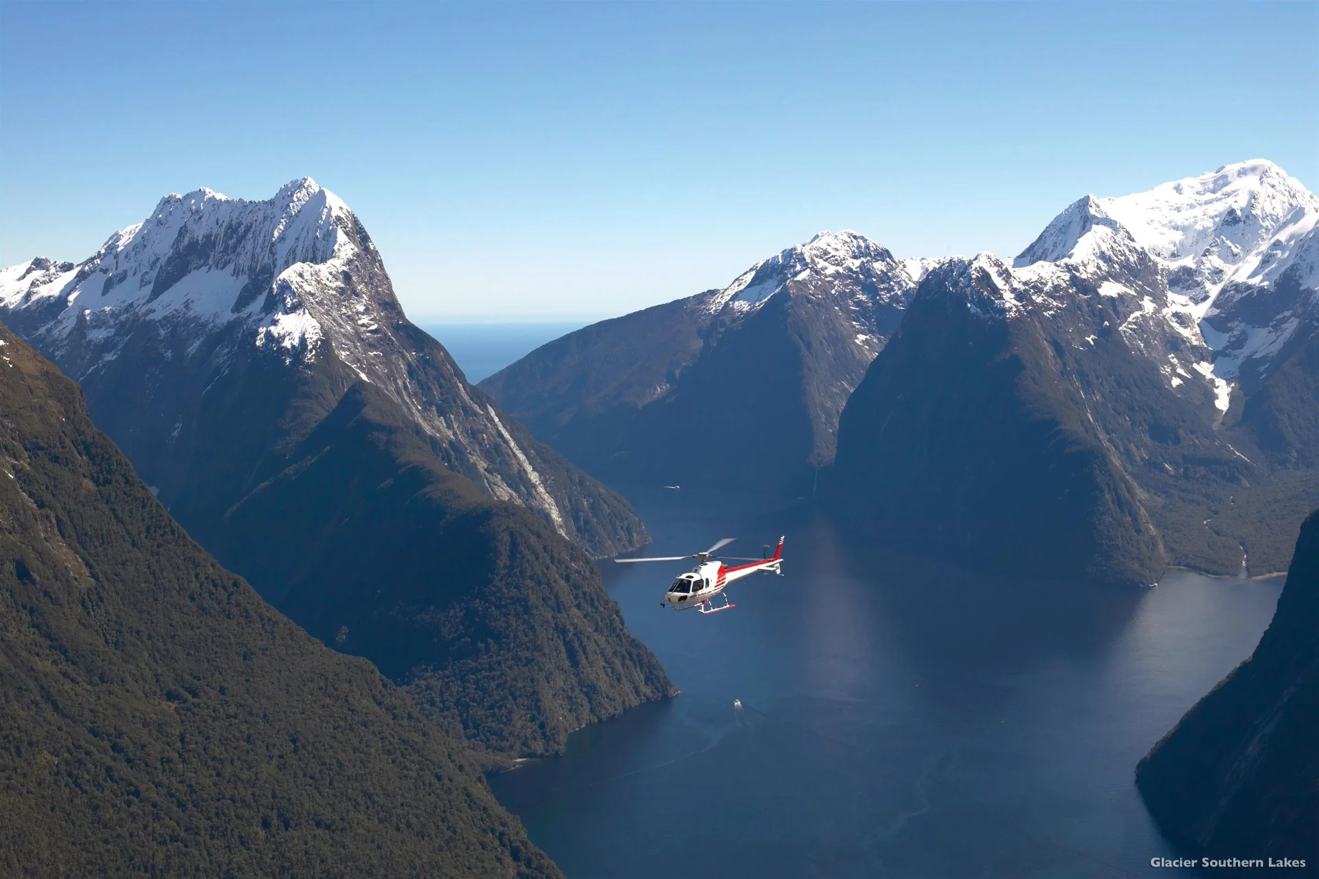 Helicopter flying over Milford Sound and the peaks of Fiordland, New Zealand
