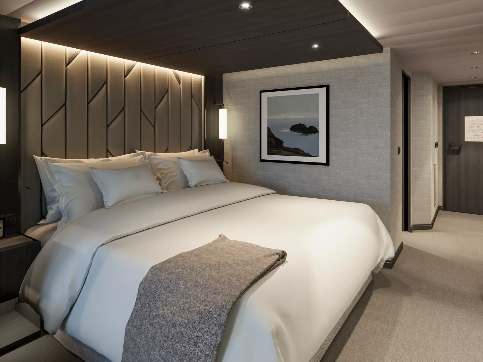 King bed with soft lighting and a padded headboard in an Explora Ocean Terrace Suite