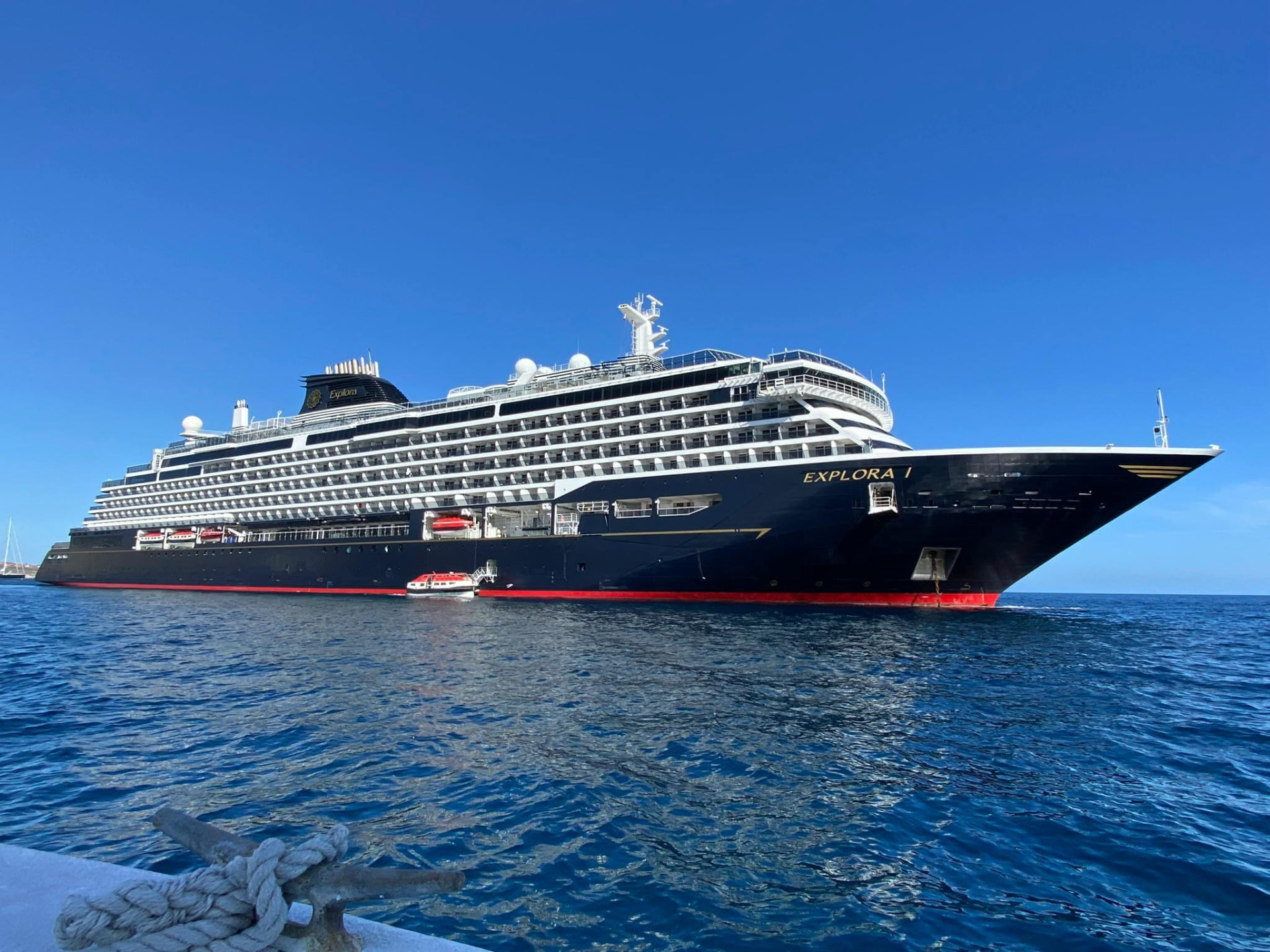 Explora I cruise ship at anchor in deep blue water under a clear sky