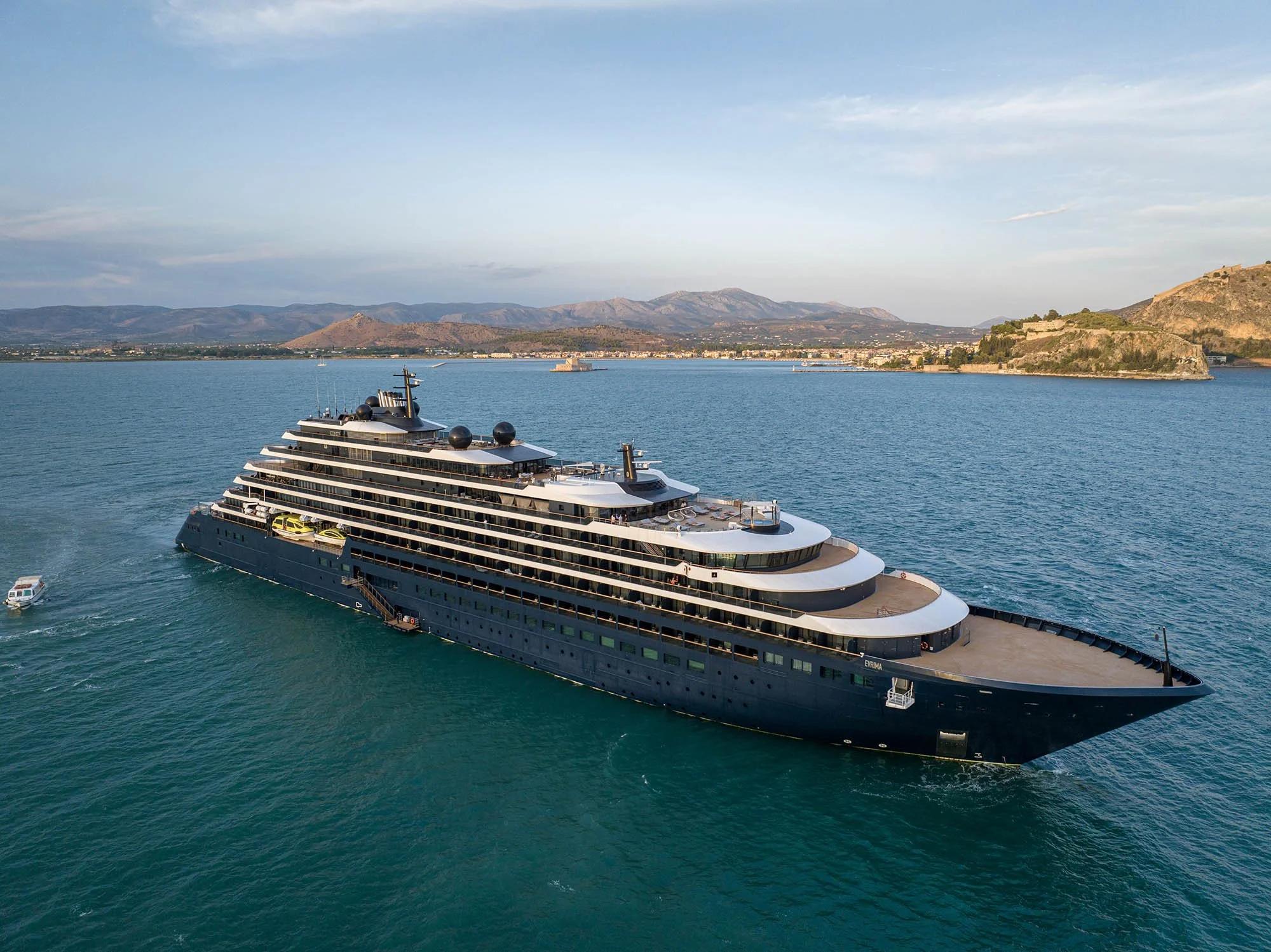 Evrima, the Ritz-Carlton Yacht Collection ship, anchored off a Mediterranean coastline