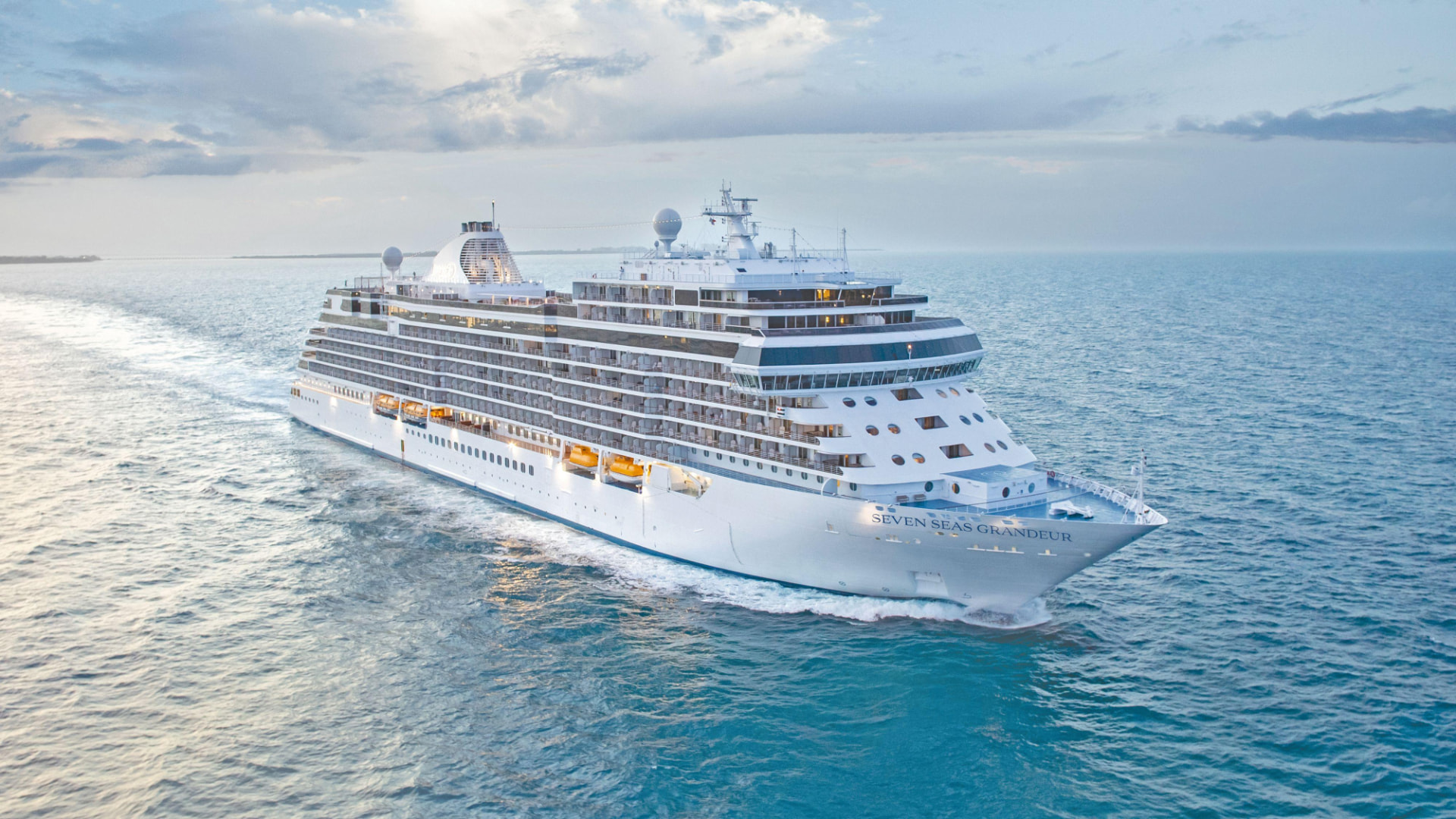 Seven Seas Grandeur cruise ship sailing on turquoise water