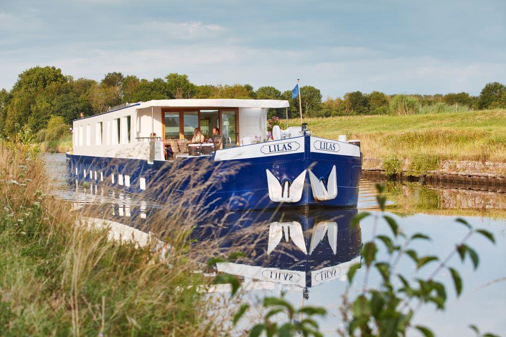 Belmond barge Lilas gliding along a canal in Burgundy, France