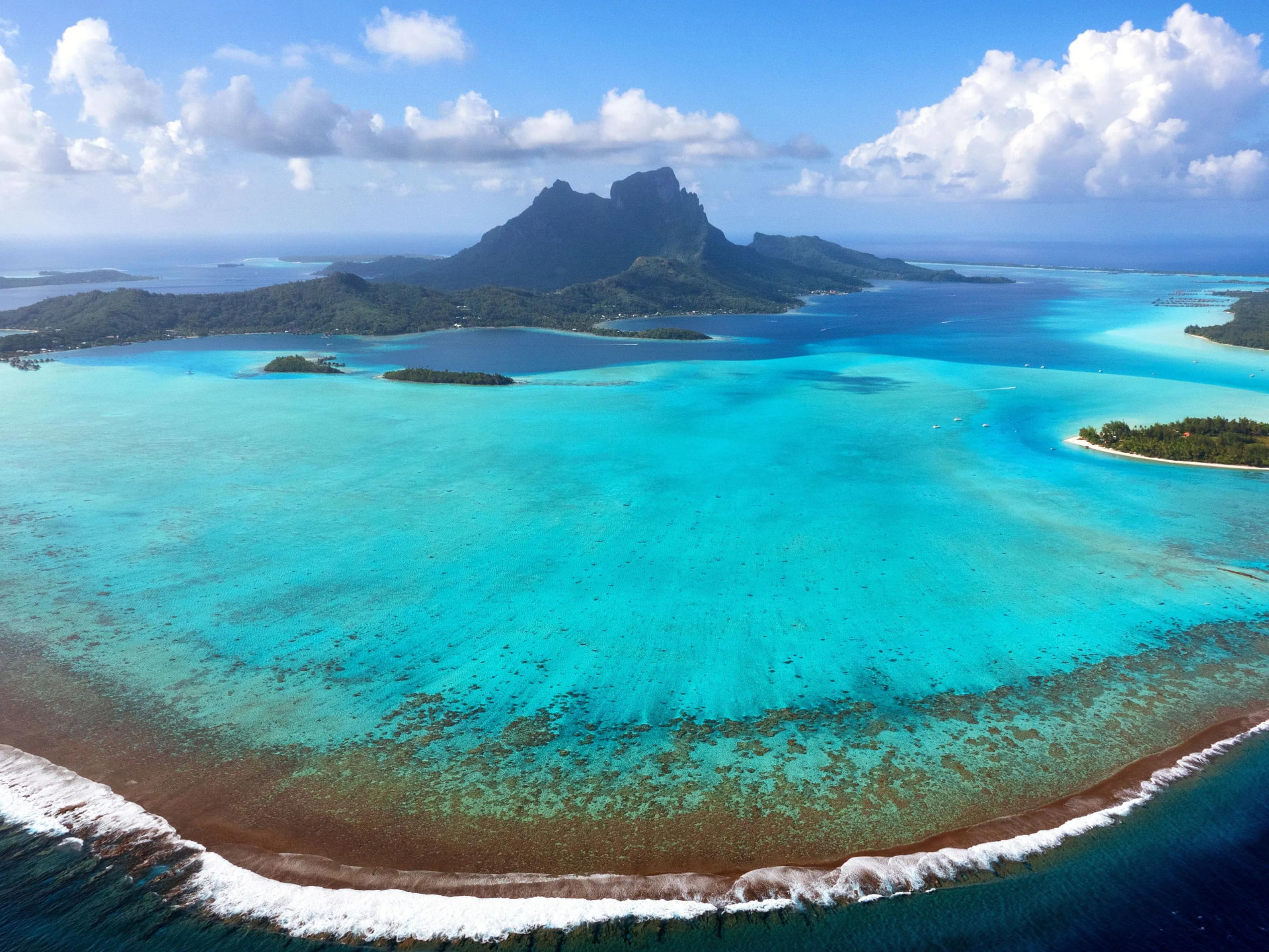 Aerial view of Bora Bora, French Polynesia, with Mount Otemanu rising over the turquoise lagoon, motus and outer reef
