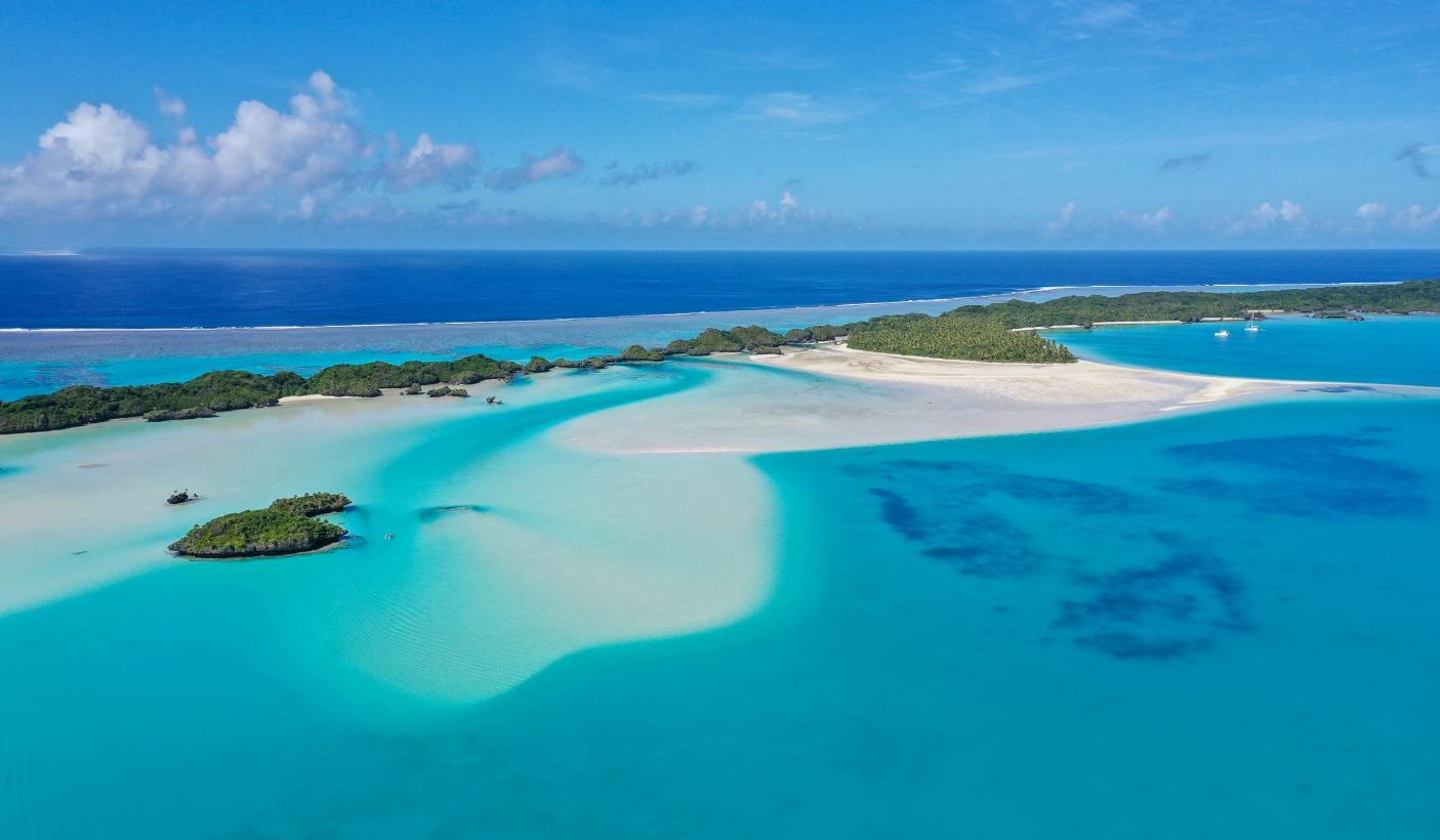 Aerial view of a white-sand bar and small green islets in a turquoise lagoon in Fiji