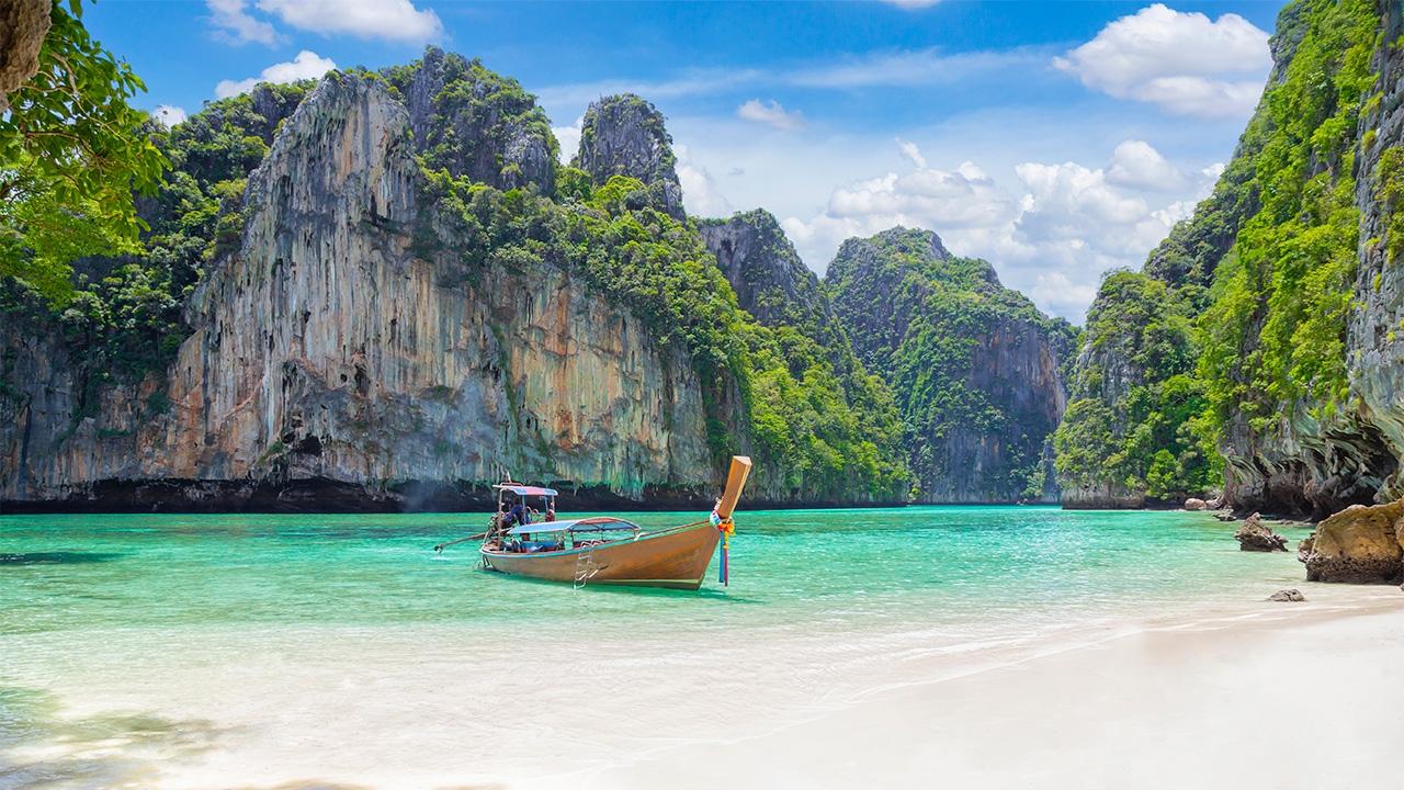 Long-tail boat on the turquoise water of Maya Bay near Phi Phi Leh, Thailand